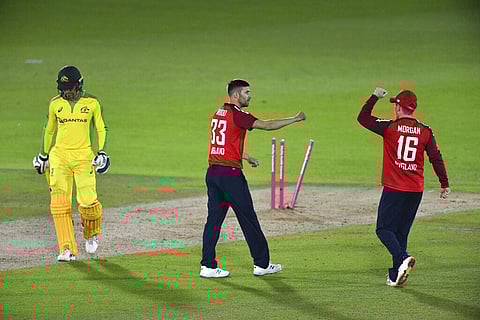 England's Mark Wood, center, celebrates with captain Eoin Morgan, right, the dismissal of Australia's Alex Carey, left, during the first Twenty20 cricket match.(Photo | AP)