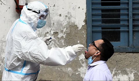 A health worker collects swab sample from a man for coronavirus rapid antigen and RT-PCR testing. (Photo | Parveen Negi, EPS)