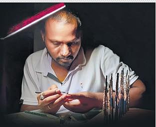 Miniature artist  S Nanjundaswamy chisels away at a pencil lead