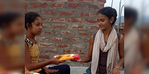 Mausam Kumari (R) gives a sanitary pad to a girl. (Photo| EPS)