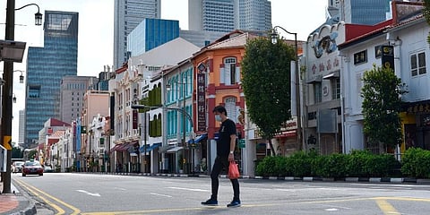 A man wearing a face mask crosses the street in Singapore’s Chinatown district. (Photo | AP)