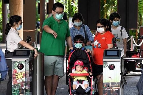 Members of a family wearing face masks enter Jurong Bird Park for a visit in Singapore. (File Photo | AFP)
