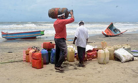 Fishermen collect their equipment, which was washed ashore along with the capsized boat, due to the strong sea waves and the heavy rain at the Kozhikode beach. (Photo | Manu R Mavelil, EPS)