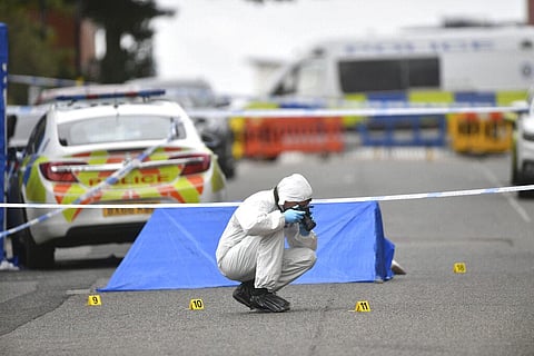 A police forensics officer taking photographs in Irving Street, in Birmingham after a number of people were stabbed. (Photo | AP)