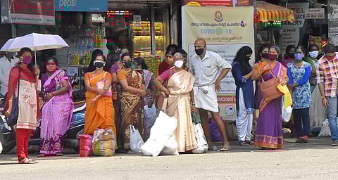 People waiting for the bus at the bus stop near Chalai market in Thiruvananthapuram. (Photo | B P Deepu, EPS)