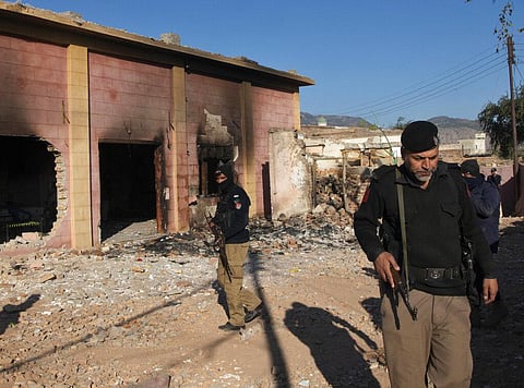 Police officer stand guar in a Hindu temple which was set on fire and demolished by a mob led by Islamists, in Karak, Pakistan. (Photo | AP)