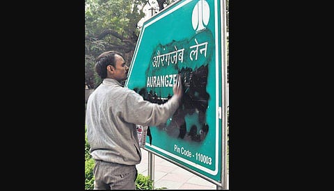 An NDMC worker cleans a board bearing the name of Aurangzeb Lane. ( File Photo | Parveen Negi, EPS)
