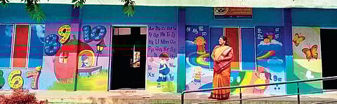 N Poonkodi stands in front of the wall she got painted at the Panchayat Union Primary School in Karukakollai of Krishnagiri district. She spent `30,000 from her pocket on the project | express