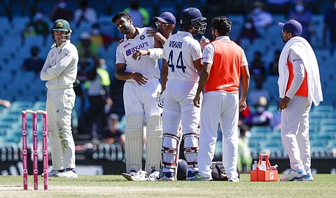 Ravichandran Ashwin, second left, receive treatment after he was hit while batting during play on the final day. (Photo | AP)