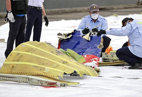 Investigators of Indonesian National Transportation Safety Committee inspect parts of Sriwijaya Air SJ-182 recovered from the waters off Java Island where it crashed. (Photo | AP)