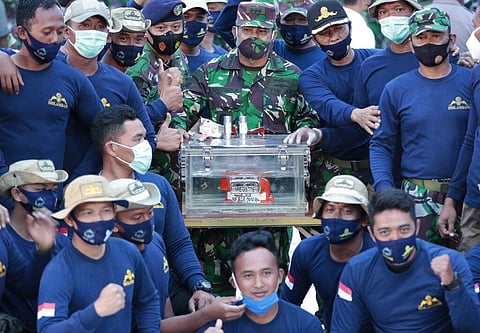 Indonesian Navy personnel pose for photos with the flight data recorder recovered from the wreckage of Sriwijaya Air flight SJ-182. (Photo | AP)