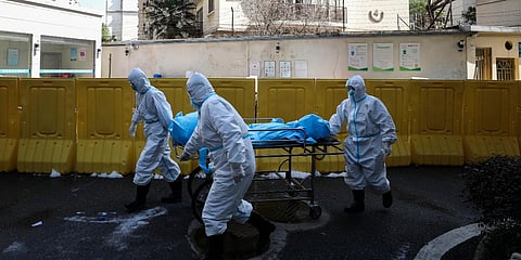 Medical workers move a person who died from COVID-19 at a hospital in Wuhan. (File photo| AP)