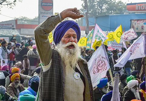 Farmers during their ongoing agitation over the new farm reform laws at Singhu border in New Delhi Tuesday. (Photo | PTI)