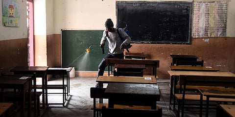 A worker seen spraying sanitizer at the school premises before the opening of classes for the 10th and 12th students in New Delhi. (Photo | Parveen Negi, EPS)