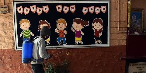 A worker seen spraying sanitizer at the school premises before the opening of classes for the 10th and 12th students in New Delhi. (Photo | Parveen Negi, EPS)