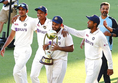 Rishabh Pant carries the trophy as he celebrates with his teammates after defeating Australia by three wickets. (Photo | AP)