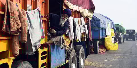 A farmer sitting inside a parked truck at Ghaziabad border on a chilly afternoon. (Photo| Parveen Negi, EPS)