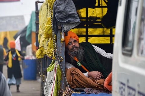 A farmer rests at Singhu border during an ongoing protest against the new farm laws, in New Delhi. (Photo | PTI)