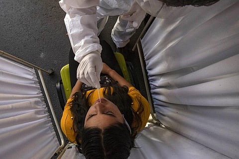 A healthcare worker takes a nasal swab sample to test for the new coronavirus. (Photo | AP)