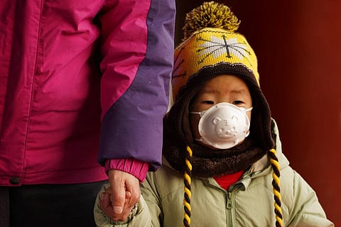 A child wears a mask with a tiger imprint as he visits Jingshan park during a snow day in Beijing Tuesday, Jan. 19, 2021. (Photo | AP)