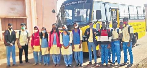 OAV students stand beside the newly-provisioned school bus in Sundargarh. (Photo | EPS)