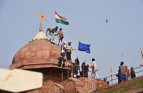 Farmers post flags on a dome of Red Fort after their tractor parade on Republic Day, in New Delhi. (Photo | PTI)
