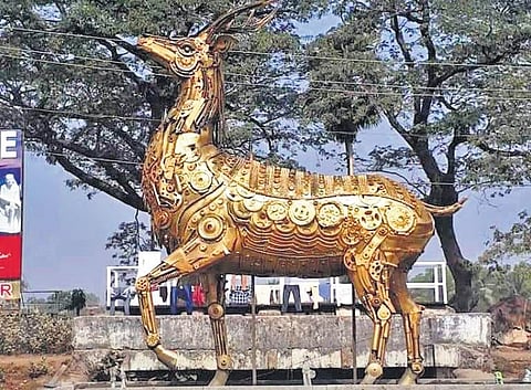 A 12 feet golden deer statue made out of of metal scraps.