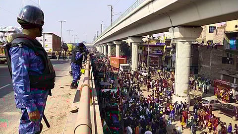 Security forces watch on as massive tractor parade by protesting farmers takes place near Tikri border, New Delhi. (Photo | EPS/Parveen Negi)