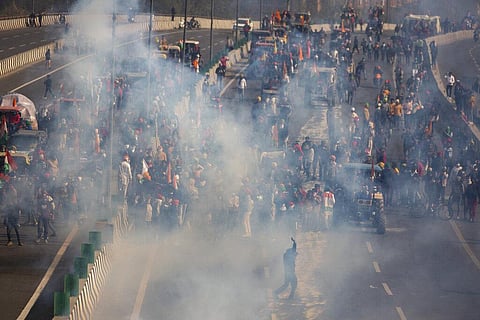 Protesting farmers are seen amid tear gas smoke fired by police in an attempt to stop them from marching to the capital during India's Republic Day celebrations in New Delhi. (Photo | AP)