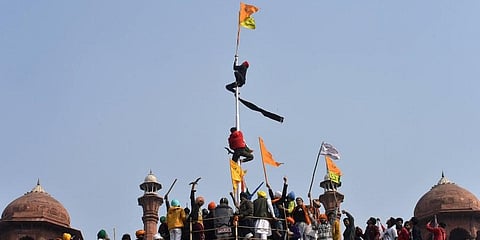 Farmers hoist flags at the Red Fort during the 'Kisan Gantantra Parade' amid the 72nd Republic Day celebrations in New Delhi. (Photo | PTI)