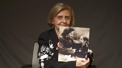 Tova Friedman, an 82-year-old Polish-born Holocaust survivor holding a photograph of herself as a child with her mother, who also survived the Nazi death camp Auschwitz. (Photo | AP)
