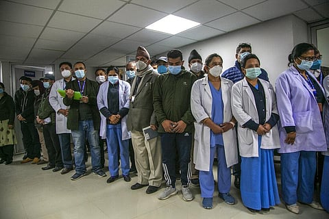 Health workers observe a minute of silence in memory of people who died due to COVID-19 before administering vaccine at Teaching Hospital in Kathmandu, Nepal. (Photo | AP)