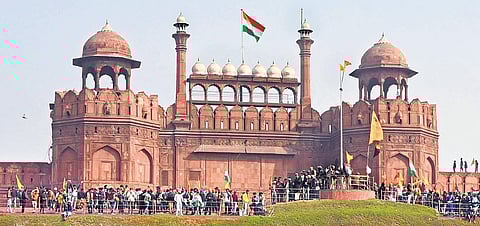 Farmers and their supporters hoist the Nishan Sahib on the ramparts of the Red Fort after they forcibly entered the 17th century monument in New Delhi. (Photo | Parveen Negi, EPS)