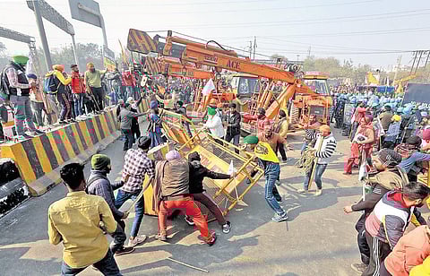 Farmers and their supporters remove barricades during the tractor rally near  Sanjay Gandhi Transport Nagar in New Delhi. (Photo | Shekhar Yadav, EPS)