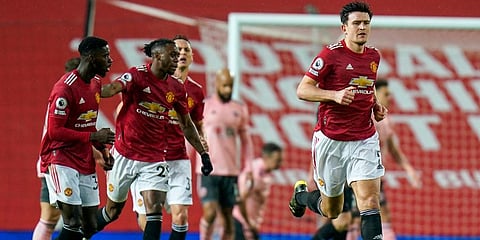 Manchester United's Harry Maguire (R) reacts after scoring his team's first goal during the EPL match against Sheffield United at Old Trafford. (Photo | AP)