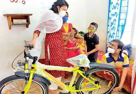 District Collector M Anjana gifting the new cycle to Suneesh’s son Justine at his residence on Tuesday