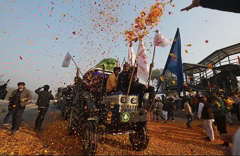 Farmers shower flower petals on fellow farmers riding on their tractors. (File Photo | Shekhar Yadav, EPS)