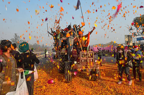 Farmers shower flower petals on fellow farmers riding on their tractors after breaking the police barricades at Singhu border in New Delhi. (Representational Photo | PTI)