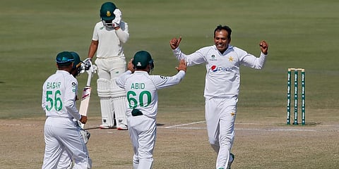 Pakistan's spinner Nauman Ali (R) celebrates with teammates after taking the wicket of South Africa's Temba Bavuma during the fourth day of the first Test match in Karachi. (Photo | AP)