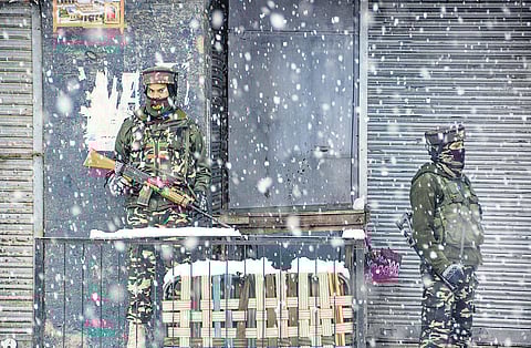 Paramilitary personnel stand guard amid biting cold and heavy snowfall in Srinagar. (File photo| PTI)