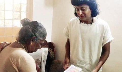 Boby Chemmanur collecting land document from Vasantha