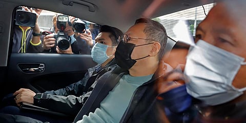 Former law professor Benny Tai (C), a key figure in Hong Kong's 2014 Occupy Central protests, sits in a car after being arrested by police. (Photo| AP)