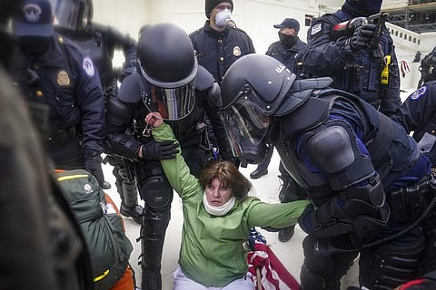A woman is helped up by police during a rally Wednesday, Jan. 6, 2021, at the Capitol in Washington. (Photo | AP)
