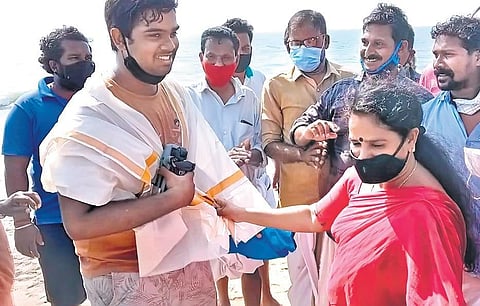 Devang Subil being lauded by local residents after the fishermen were brought toThalikkulam beach in Thrissur on Tuesday