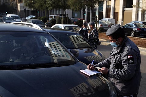 A cop issues fines on vehicles that violate the odd and even license plate rule on alternating days as the country began a three-week lockdown to limit the spread of coronavirus. (Photo | AP)