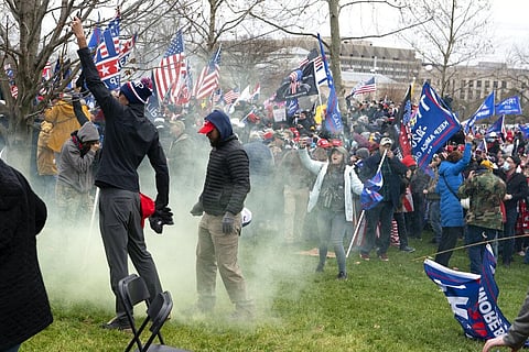 In this Jan. 6, 2021, file photo, supporter of President Donald Trump protest as U.S. Capitol Police officers shoot tear gas at demonstrators. (Photo | AP)