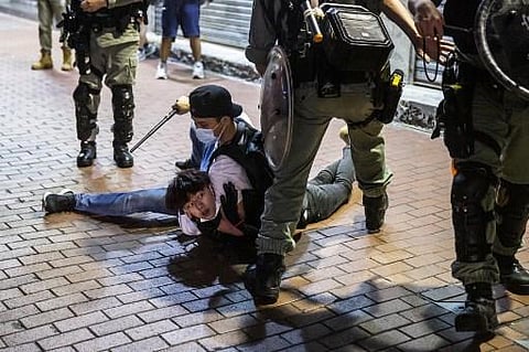 A pro-democracy demonstrator in Hong Kong is held on the ground before getting arrested. Protests against the national security bill had brought life to a standstill in Hong Kong for months in early 2