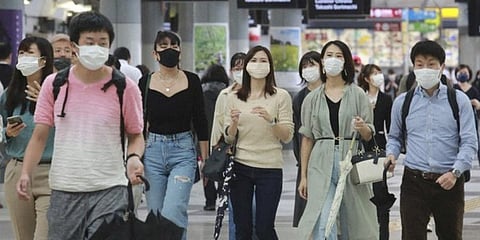 People wearing face masks to help protect against the spread of the coronavirus walk through the train station in Tokyo. (Photo | AP)
