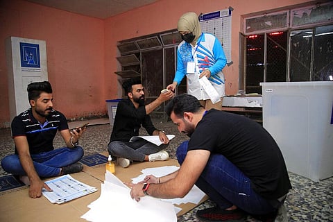 Election officials count ballots as they close a polling station at the end of voting in parliamentary elections, in Baghdad, Iraq. (Photo | AP)