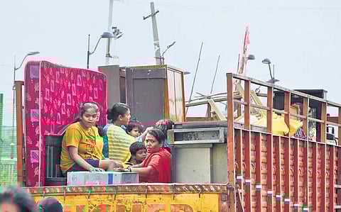 A family shifts their household articles to a nearby location after their house in Meerpet was flooded by heavy rains | RVK Rao